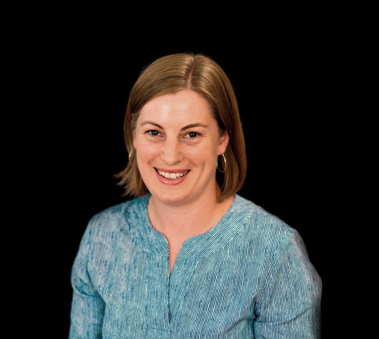 Charlotte Wickham standing in front of black backdrop