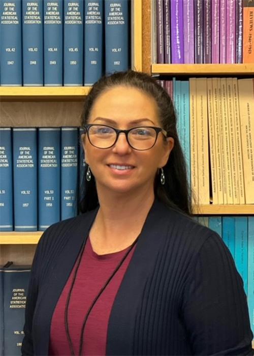 Denice Huber in front of bookcase