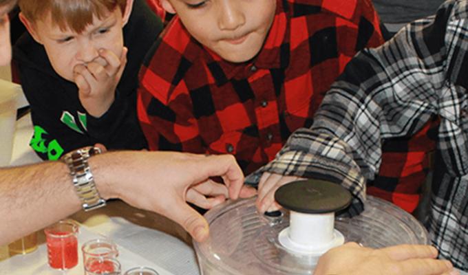 children looking at science themed booth