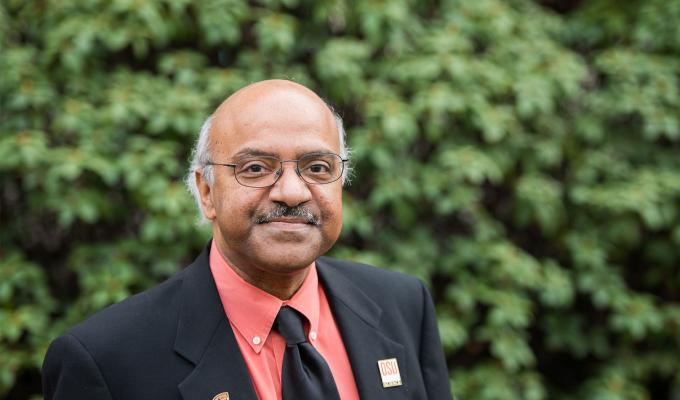 Sastry Pantula standing in front of shrubbery.